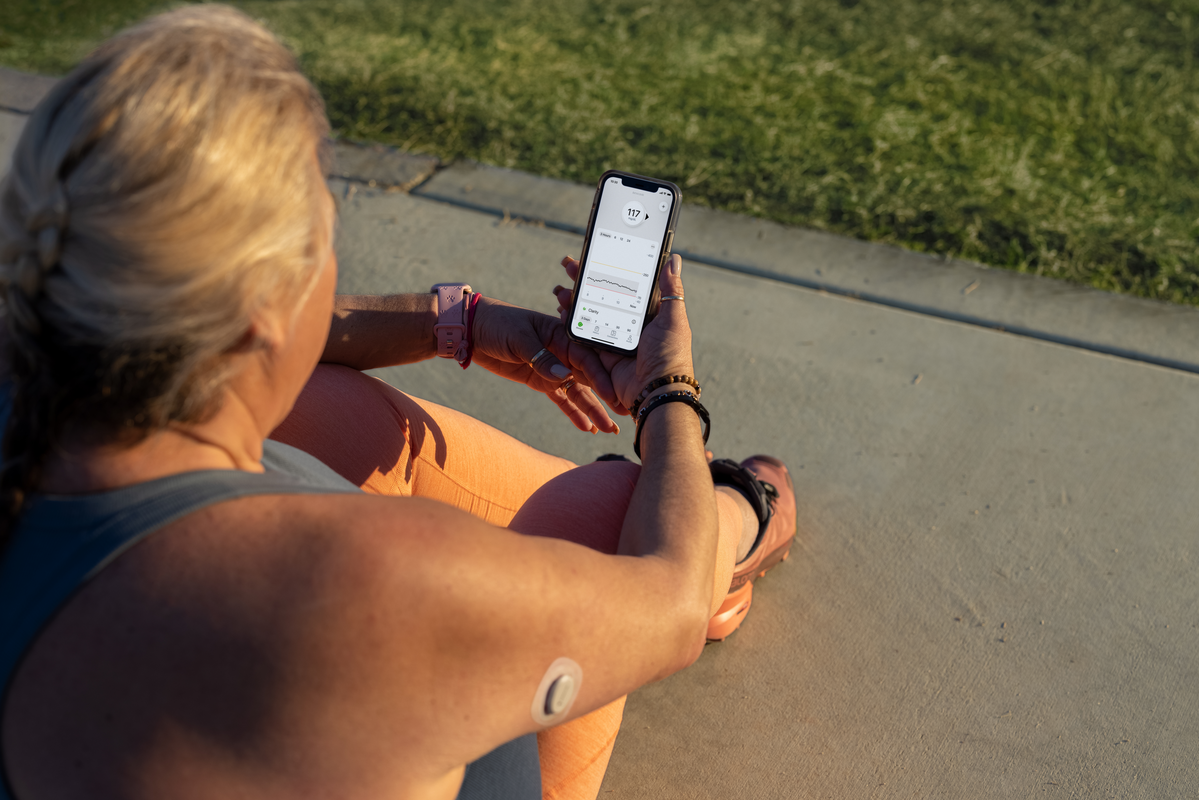 Dexcom CGM user examining results on phone
